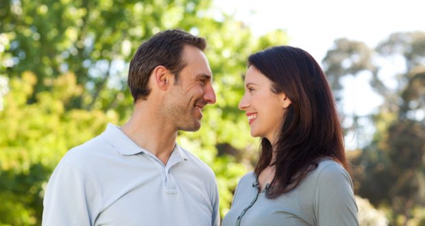 Casal Sorrindo com Árvores ao Fundo