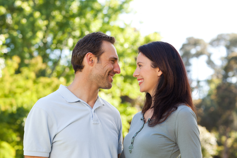 Casal Sorrindo com Árvores ao Fundo