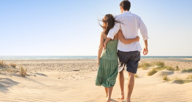 Casal caminhando na praia