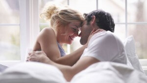 Casal sorrindo na cama